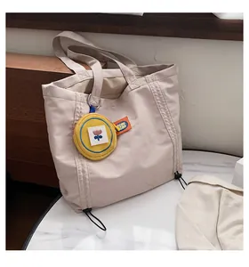 Detail of beige canvas tote with floral coin purse and black drawstring closure