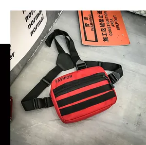Detail of red tactical crossbody bag with black webbing straps and front fashion logo