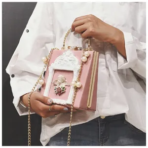 Detail of pink retro box bag with Cupid relief and elegant pearl chain strap