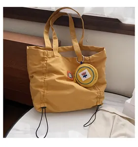 Detail of yellow canvas tote bag with drawstring sides and matching mini round floral coin purse