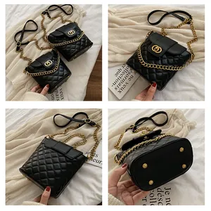 Detail view of black quilted bucket bag showing gold chain strap and bottom protective feet