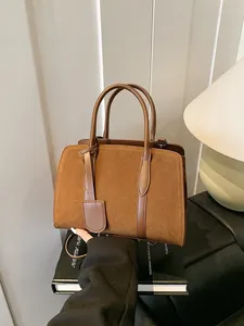 Vintage karamelbruine suède handtas met grote capaciteit en dubbele handvatten in warme studio