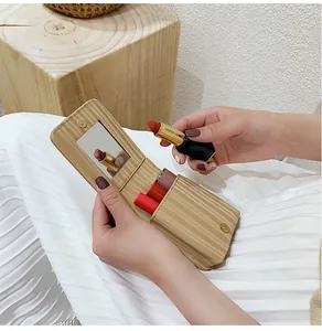 Macro view of portable makeup pouch showing built-in mirror and lipstick slots