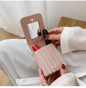 Detail view of pink wavy lipstick bag showing built-in mirror and golden magnetic closure