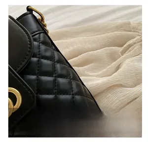 Close-up of black quilted leather bucket bag with elegant golden metal clasp detail