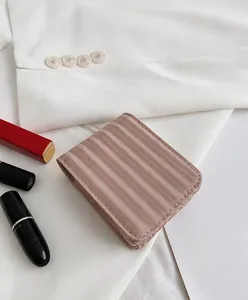 Nahaufnahme der rosa Mini-Kosmetiktasche mit Wellenstruktur und Magnetverschluss für Damen