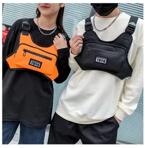 Close-up of black and orange street style chest rig bags with adjustable nylon straps