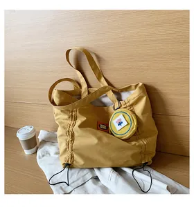 Detailed view of yellow canvas tote bag with drawstring design and matching floral pouch