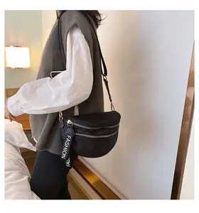 Close-up of black crescent nylon crossbody bag with gold double zippers and fashion strap