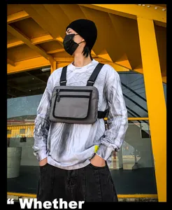 Sac de poitrine tactique gris avec bretelles réglables sur fond industriel jaune vif