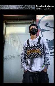 Dettaglio della borsa da petto streetwear a scacchi con stampa della scritta TOYUBAG