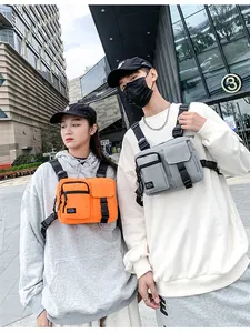 Detail of grey and orange tactical chest bags featuring multi-pocket storage and durable buckles