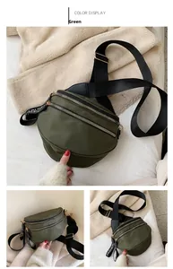 Detail of green nylon crossbody bag showing dual parallel zippers and fashion straps