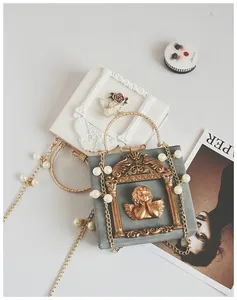 Detailed macro view of vintage relief handbag with angel motif and pearl chain handle