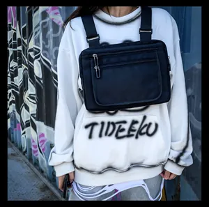 Détail du sac de poitrine tactique noir avec plusieurs poches zippées sur un mannequin