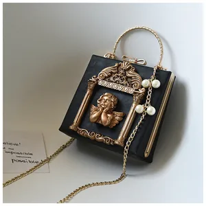 Macro shot of vintage black crossbody bag with baroque angel relief and gold metal handle