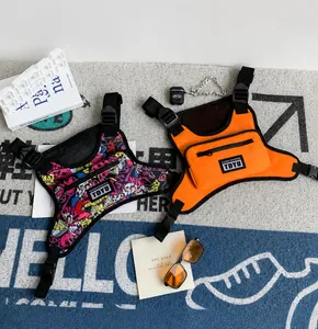 Detailansicht taktischer Brusttaschen mit Graffiti-Print und orangefarbenem Nylongewebe