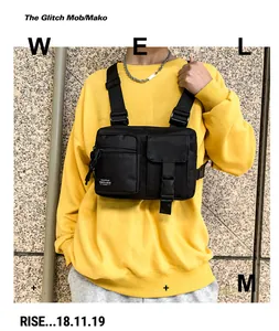 Detail of black tactical chest bag with plastic buckle and TOFU-BAG label on yellow hoodie