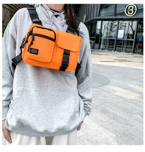 Detail of bright orange tactical chest bag featuring nylon fabric and adjustable buckles