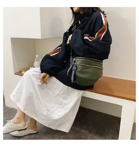 Detail of dark green nylon crossbody bag with dual zippers and fashion straps