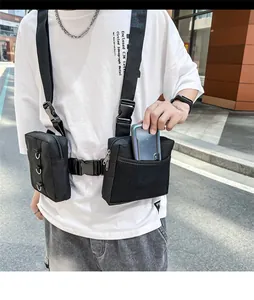Detail of black tactical chest bag showing dual zipper pockets and side mesh pouch