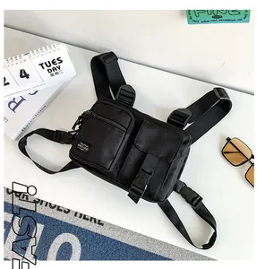 Detail of black tactical chest bag with dual functional pockets and adjustable nylon straps