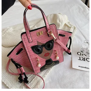 Dettaglio della borsa rosa con trama a coccodrillo e raffinati accenti di perle