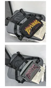 Dettaglio borse da petto hip hop nero e grigio con logo fiamma e cinturini in nylon
