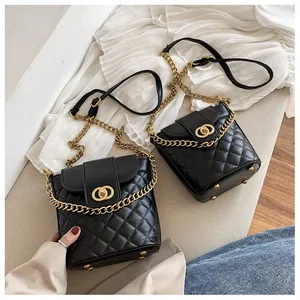 Detailed view of quilted black bucket bags with gold chain straps and metal ring buckles