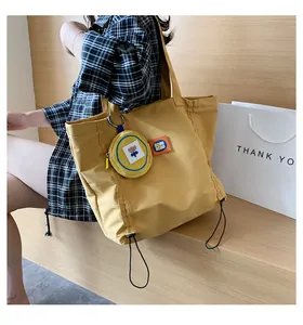 Detail of yellow canvas tote bag with mini coin purse and adjustable drawstring bottom