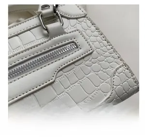 Macro shot of white crocodile embossed leather texture with silver metal zipper detail