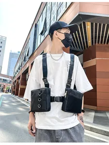 Detail of black tactical chest bag showing dual pouches with mesh and D-rings on street model