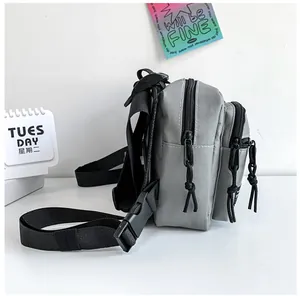 Detail of gray nylon chest bag showing wear-resistant fabric texture and layered zippers