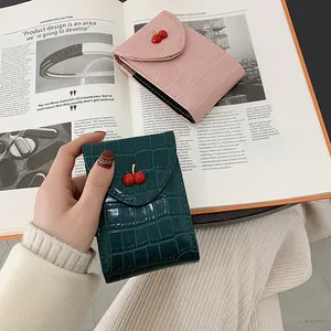 Portafoglio con motivo a pietra e fibbia a ciliegia in rosa e verde su una rivista