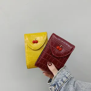 Mini borsa con ciliegie in ecopelle con goffratura a coccodrillo in rosso e giallo