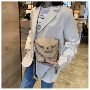 Close-up of quilted beige bucket bag with gold interlocking buckle and chain detail