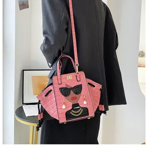 Dettaglio borsa rosa effetto coccodrillo con ricamo cartoon e chiusura dorata
