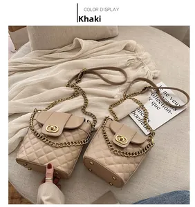 Detailed macro view of khaki quilted bucket bag with gold metal lock and chain strap