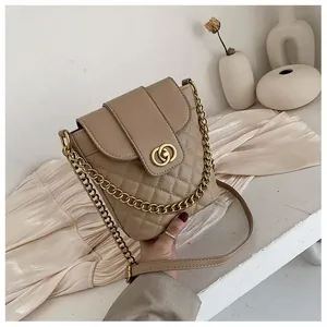 Detailed close-up of quilted khaki bucket bag with dual ring gold metal lock and chain strap