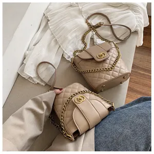 Close-up of beige quilted bucket bag with chain strap and gold hardware detail