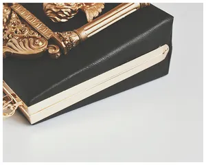 Detail view of vintage baroque gold relief on black pebbled leather crossbody bag