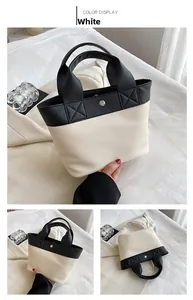 Dettaglio borsa a mano bicolore in pelle PU bianca martellata con chiusura magnetica