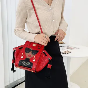 Borsa rossa texture coccodrillo con ritratto cartoon e perle indossata da modella