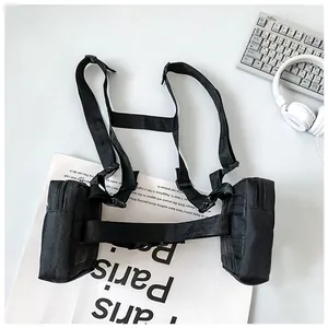 Flat lay of a black tactical chest bag with dual zipper pouches and nylon straps