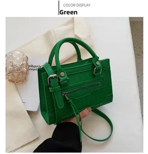 Detail shot of green crocodile-embossed handbag with silver hardware and adjustable strap