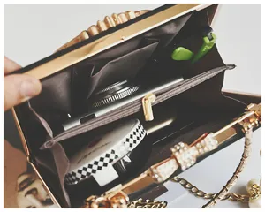 Internal view of evening clutch showing two compartments and storage space for camera and lipstick