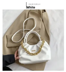 Close-up of white PU leather bag with elegant pleated details and gold chain decoration