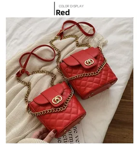 Detail of red quilted leather bucket bag with gold interlocking buckle and chain strap