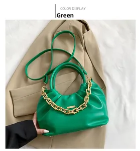 Detail of green pleated crossbody bag featuring a chunky gold chain and smooth PU leather