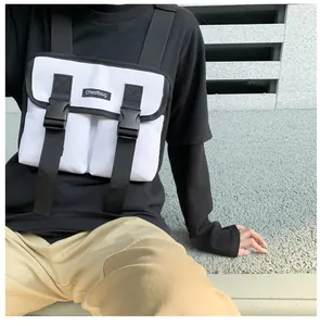 Detail of white tactical chest bag featuring black buckles and adjustable nylon straps